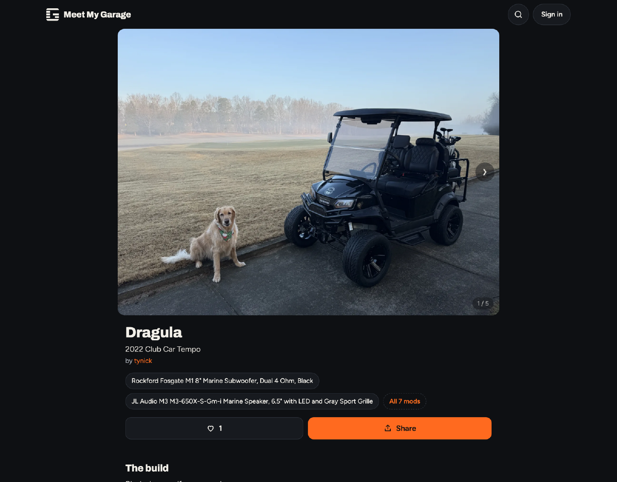 A black 2022 Club Car Tempo golf cart called Dragula with a golden retriever sitting next to it